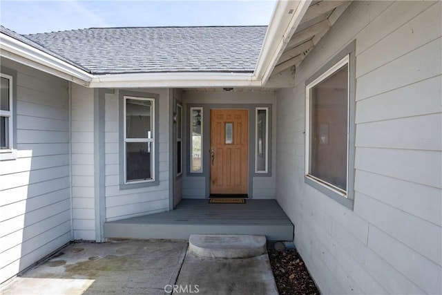 property entrance featuring a shingled roof
