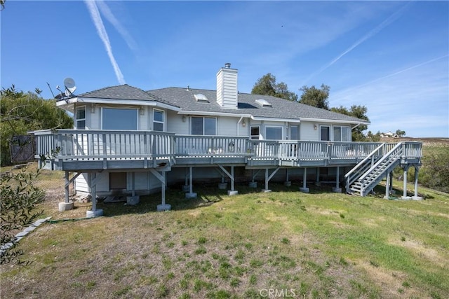 back of house featuring a chimney, stairway, a deck, and a lawn
