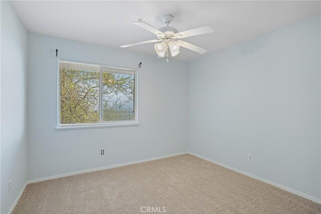 unfurnished room with baseboards, carpet flooring, and a ceiling fan