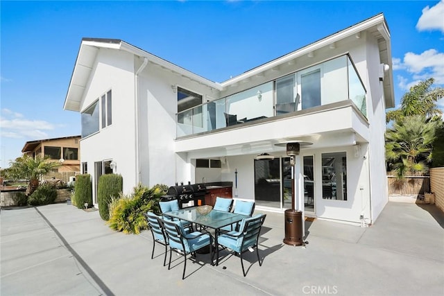 16449 Ladona Cir, Huntington Beach, CA 92649 - rear view of property featuring a balcony, stucco siding, a patio, ceiling fan, and outdoor dining space