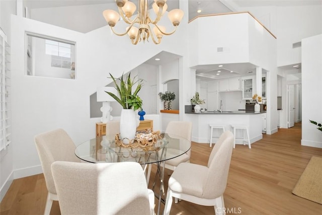dining area featuring visible vents, baseboards, an inviting chandelier, and light wood-style flooring