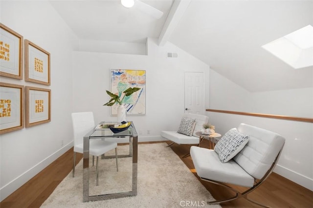 office space with lofted ceiling with skylight, wood finished floors, and baseboards