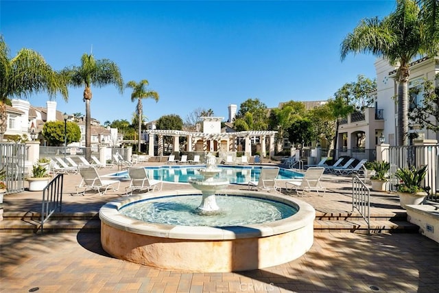 community pool with a patio and fence