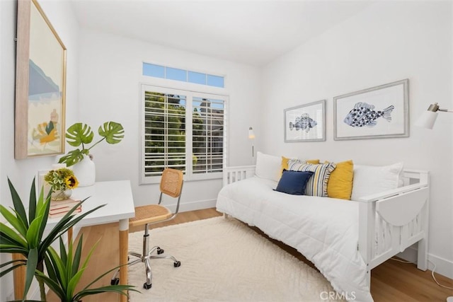 bedroom featuring baseboards and wood finished floors
