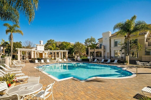 pool with a patio, fence, and a pergola