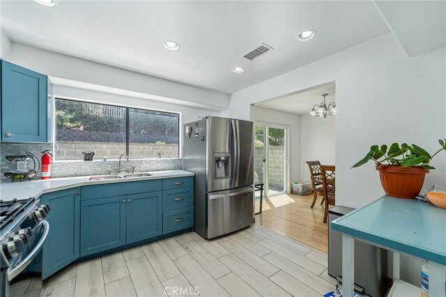 1116 Herbert Ave, Los Angeles, CA 90063 - kitchen featuring appliances with stainless steel finishes, a sink, blue cabinetry, light countertops, and a chandelier