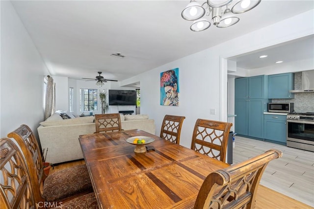 1116 Herbert Ave, Los Angeles, CA 90063 - dining room with a fireplace, light wood-type flooring, ceiling fan, and a chandelier