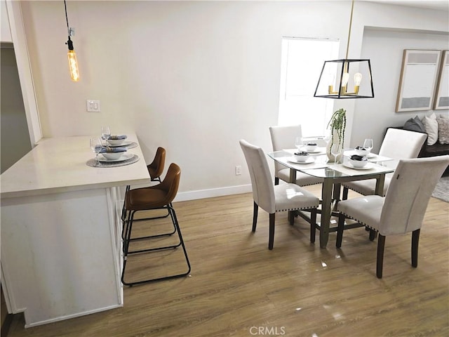 dining space featuring wood finished floors and baseboards