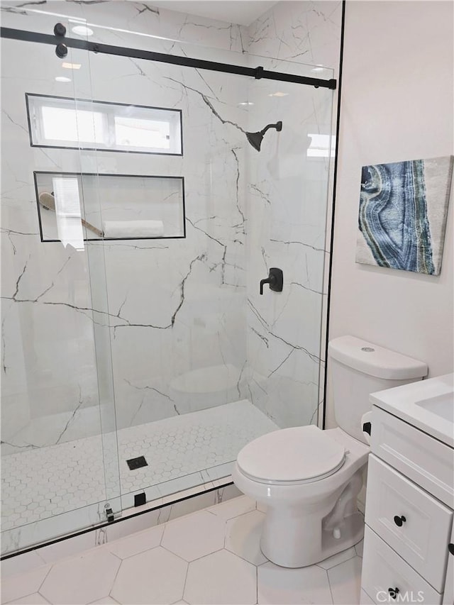 full bath featuring a marble finish shower, toilet, and vanity