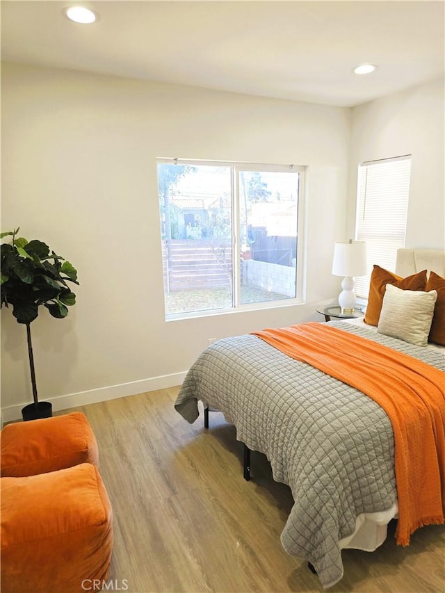 bedroom with recessed lighting, light wood-style flooring, and baseboards