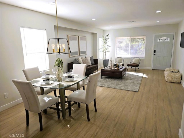 dining room featuring a notable chandelier, recessed lighting, light wood-style floors, and baseboards