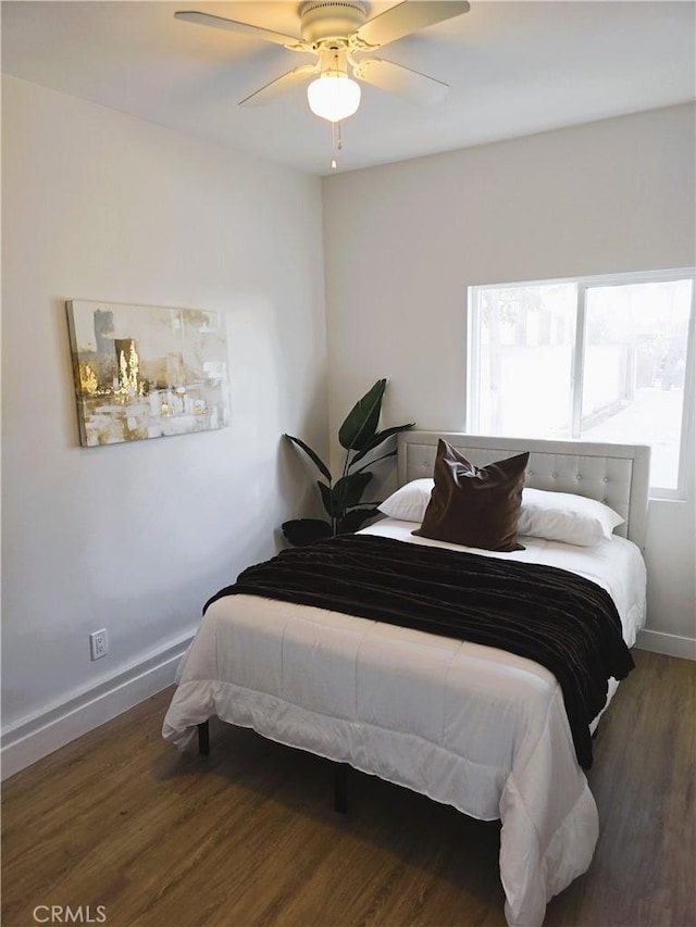 bedroom featuring a ceiling fan, wood finished floors, and baseboards