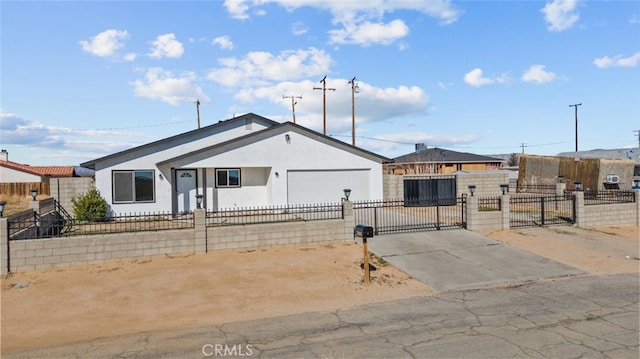 view of front of property featuring an attached garage, a fenced front yard, stucco siding, driveway, and a gate