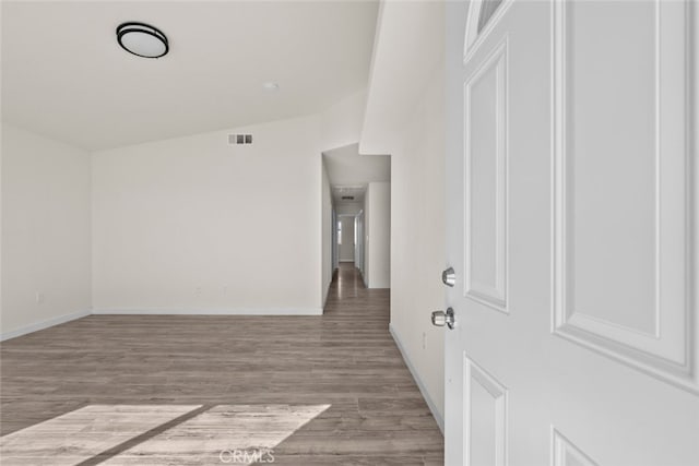 interior space with wood finished floors, visible vents, and baseboards