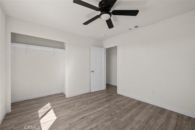 unfurnished bedroom with visible vents, ceiling fan, baseboards, wood finished floors, and a closet