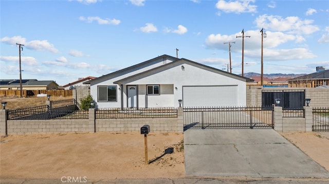 view of front of house featuring a fenced front yard, an attached garage, driveway, and stucco siding