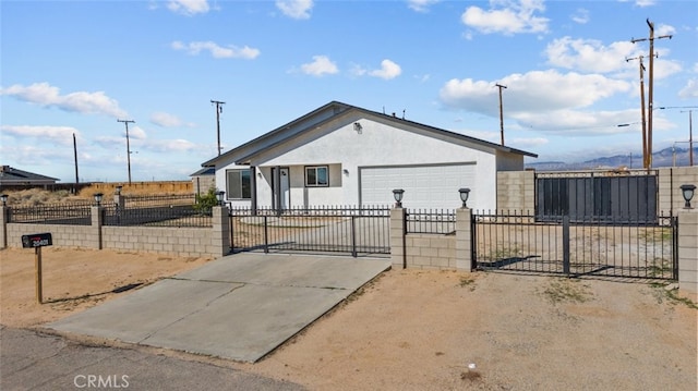 view of front of house with a fenced front yard, an attached garage, driveway, and a gate