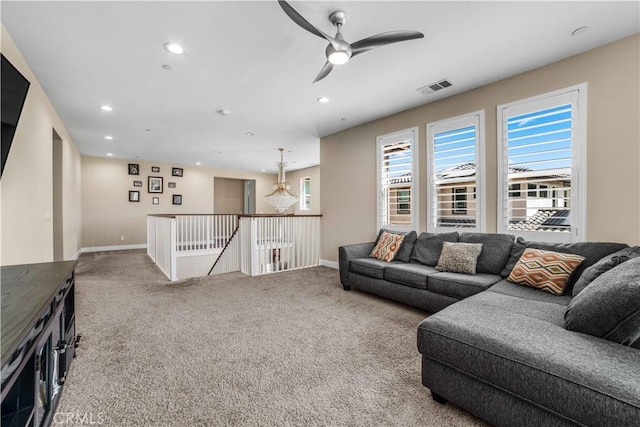 living area featuring ceiling fan with notable chandelier, visible vents, recessed lighting, and carpet flooring