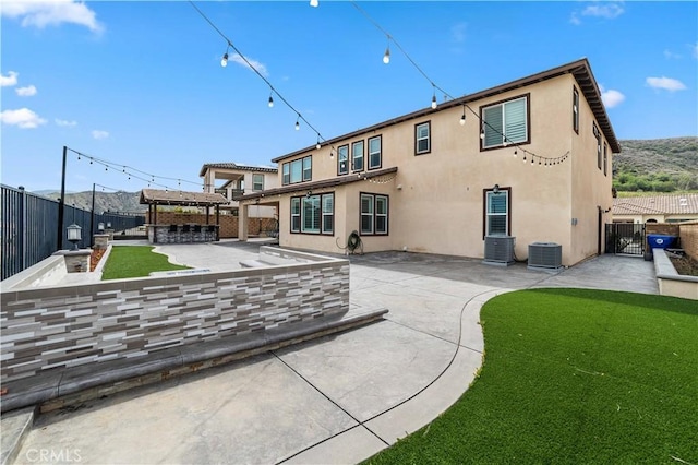 back of property featuring central air condition unit, a patio, a fenced backyard, and stucco siding