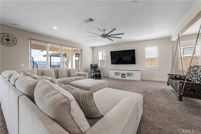 living room with ceiling fan, a healthy amount of sunlight, carpet flooring, and visible vents