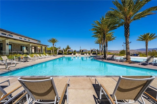 pool with a mountain view and a patio area