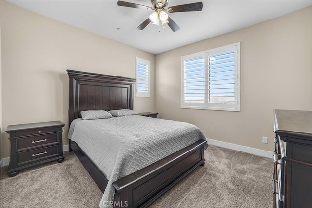 bedroom with ceiling fan, light carpet, and baseboards