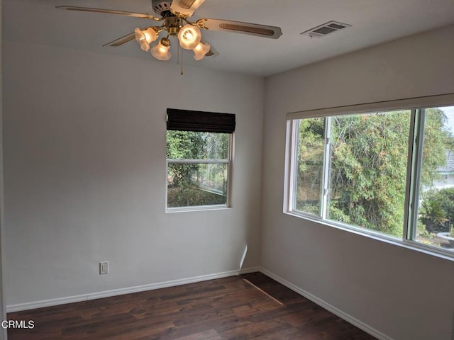 unfurnished room featuring visible vents, baseboards, wood finished floors, and a ceiling fan
