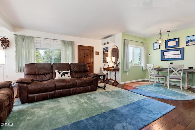 living room featuring wood finished floors, baseboards, and a wall mounted AC