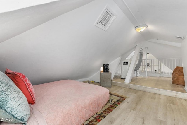 bedroom featuring vaulted ceiling, wood finished floors, and visible vents
