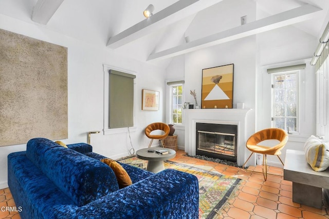 living area featuring a glass covered fireplace, high vaulted ceiling, and beamed ceiling