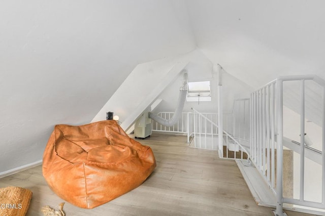 additional living space featuring wood finished floors and lofted ceiling