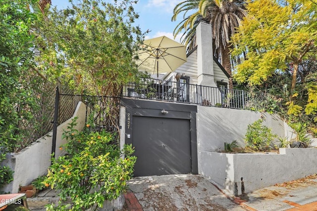 garage featuring concrete driveway and fence