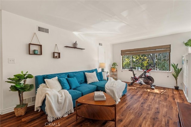 living room featuring baseboards, wood finished floors, and visible vents