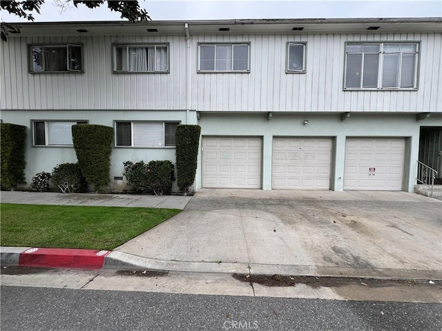 view of front of home featuring stucco siding, an attached garage, and concrete driveway