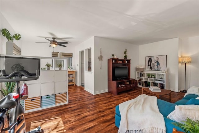 living room featuring baseboards, a ceiling fan, and wood finished floors