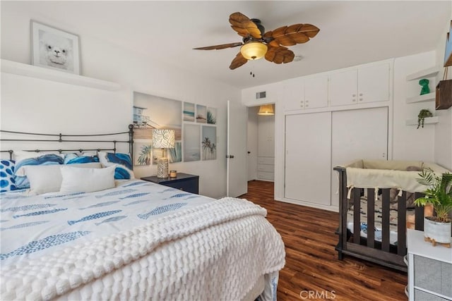 bedroom with visible vents, dark wood-style floors, a closet, and ceiling fan