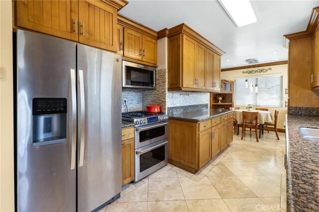 401 Holmwood Dr, Newport Beach, CA 92663 - kitchen with stainless steel appliances, backsplash, brown cabinets, ornamental molding, and dark stone counters