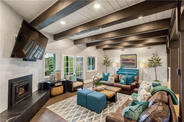 living area with wood finished floors, a premium fireplace, beamed ceiling, and baseboards