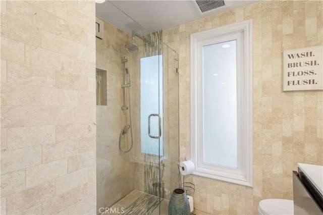 full bathroom with toilet, visible vents, a shower stall, and vanity
