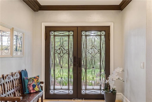 doorway featuring baseboards, ornamental molding, french doors, and plenty of natural light