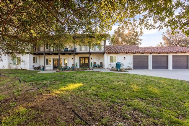 view of front of property featuring stucco siding, a front yard, concrete driveway, and an attached garage