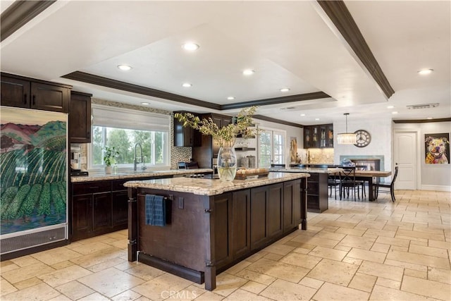 kitchen with ornamental molding, refrigerator, decorative backsplash, and a tray ceiling