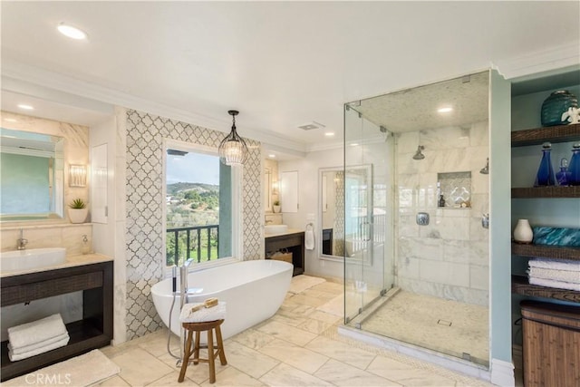 bathroom featuring crown molding, visible vents, a stall shower, a freestanding tub, and vanity