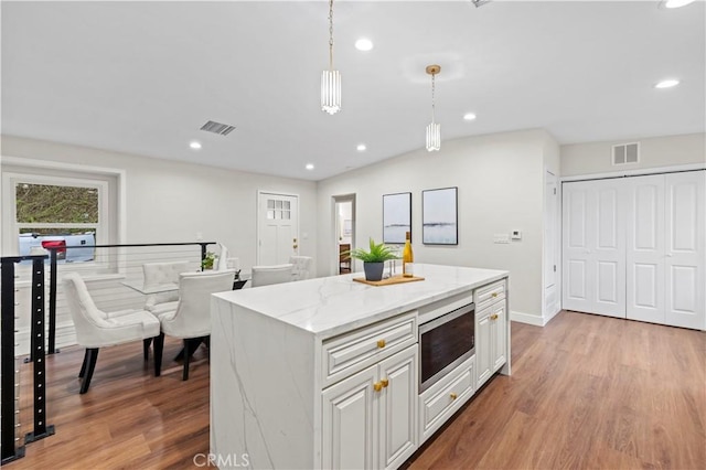 3476 Linda Vista Rd, Glendale, CA 91206 - kitchen with stainless steel microwave, light wood-style floors, and visible vents