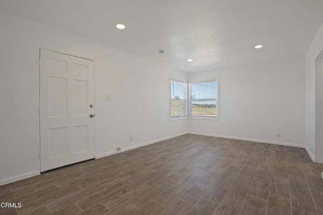 empty room featuring recessed lighting, baseboards, and dark wood finished floors