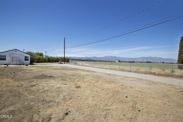 view of yard featuring a mountain view and fence