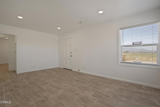 unfurnished room with baseboards and wood finished floors