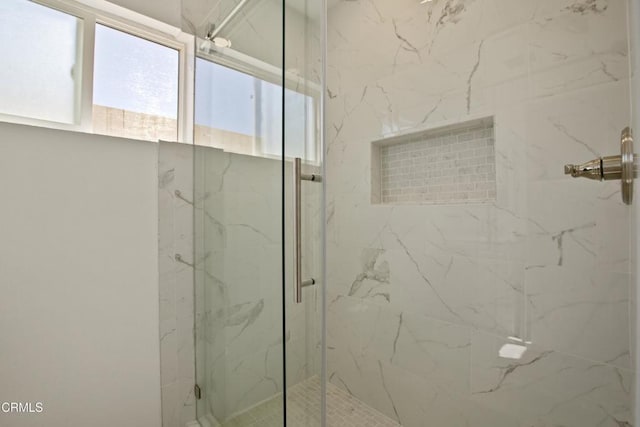 bathroom with a marble finish shower