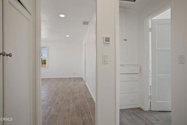 corridor with visible vents, recessed lighting, baseboards, and wood finish floors