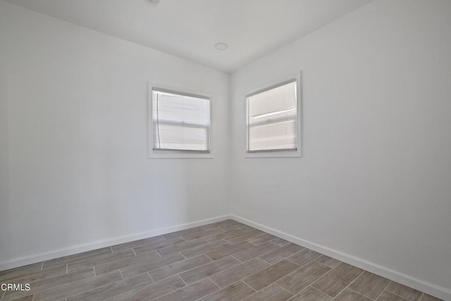 empty room featuring baseboards and wood tiled floor